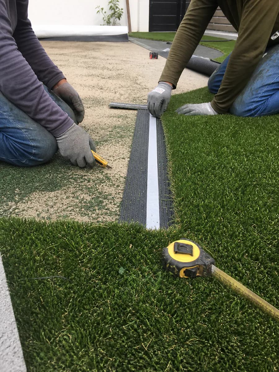 Instaladores uniendo secciones de pasto sintético